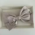 Close-up of the champagne satin bow hair clip showing elegant silky fabric texture - Pink