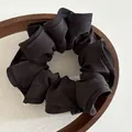 Coletero grande negro clásico de tela mate con volantes en una bandeja de madera - Negro