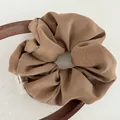 Minimalist coffee brown fabric scrunchie with natural texture on a wooden prop - Brown