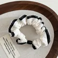 Elegante elastico bianco con riga nera, bordo in pizzo e perla decorativa nera - Bordo nero / Bianco