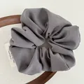 Minimalist dark grey fabric scrunchie with twill texture on a decorative wooden tray - Gray