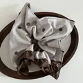 Detalle de coletero marrón de lunares con encaje y etiqueta de tela hecha a mano - Estilo Pañuelo