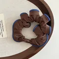 Detail of coffee brown fabric scrunchie with blue denim trim and matching smooth clasp - Brown