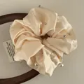 Detail of champagne satin scrunchie with silver studs and white imitation pearls - Apricot