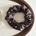 Deep coffee satin scrunchie with sparkling crystals and silver beads on a wooden tray - Brown