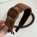 Detail van een bruine stoffen hoofdband met gebreide textuur en amberen ring - Bruin