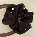 Elegant black satin scrunchie with white pearls and silver studs for sleek bun hairstyles - Black