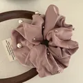 Pink satin scrunchie featuring white pearls and beads on a round wooden tray - Lotus root pink