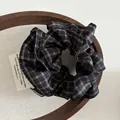 Klassisches Haargummi mit schwarz-weißem Karomuster und handgefertigtem Etikett - Schwarz