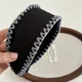 Primer plano detallado de la diadema ancha hecha a mano con bordes grises cosidos a mano en zigzag - Negro