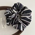 Detailed close-up of knitted striped scrunchie with soft fabric texture on a wooden tray - Navy Stripe