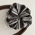 Detail of retro knit scrunchie with brown and blue stripes on a wooden tray - Coffee Striped