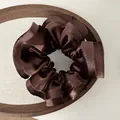 Detailed view of coffee brown satin scrunchie with silky sheen on a wooden tray - Dark Coffee