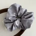 Elegant grey satin scrunchie with sparkling pearl beads on a wooden display - Blue Purple