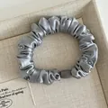 Primer plano de un coletero de satén gris con elegantes cuentas de cristal decorativas - Gris Azulado