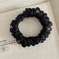Detalle de coletero de satén negro plisado con cristales grises y textura de seda - Negro