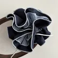 Scrunchie oversize blu scuro e a quadri con nastro bianco su un vassoio di legno - Blu navy