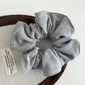Detailed texture of grey woolen scrunchie on a wooden tray with soft fabric background - Light Gray