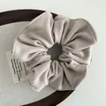 Detail of beige soft wool fabric hair scrunchie with fine stitching and textured finish - Apricot