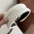 Primer plano de diadema de punto blanco que muestra textura suave y trenzado grueso - Blanco