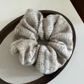 Gros plan d'un chouchou en maille beige avec motif Fair Isle et étiquette faite à la main - Kaki (Rayures Beige et Blanc)