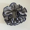 Detalle de coletero de lana gris con bordes cosidos en azul marino y textura ondulada - Gris claro