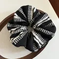 Gros plan sur un chouchou en maille rayée avec étiquette fait main sur plateau bois - Noir (Rayures Noires et Blanches)