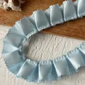 Dettaglio di nastro in raso azzurro a pieghe con bordi ondulati per decorazioni fai-da-te - Bordo a Forma di 8 / Blu