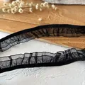 Macro detail of black pleated ruffle lace trim with mesh texture for DIY sewing and crafts - Black