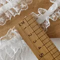 White elastic ruffled lace trim with 4cm width measurement on a rustic wood background - Single Layer Elastic Lace / White