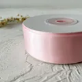 Primer plano de rollo de cinta de raso rosa para envolver regalos y manualidades - En Rollo / Rosa Claro