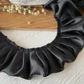 Nahaufnahme von schwarzer doppellagiger Rüschenspitze mit edler Plissee-Satin-Textur - Standard - Schwarz
