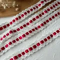 Detailansicht weißer Häkelspitze mit rotem Satinband für DIY-Näharbeiten und Deko - Rot