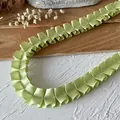 Nastro in raso plissettato verde chiaro con eleganti onde e cucitura centrale rinforzata - Stile 18 Nastro Plissettato in Raso Verde Frutta Bifacciale