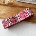 Detail view of vintage red and white checkered ribbon roll with geometric patterns - Red