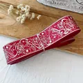 Macro view of red ribbon featuring white rose and bird patterns for DIY craft decoration - Silver Stamping - Red