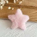 Detailansicht eines weichen rosa Plüschsterns für Bastelarbeiten auf einer Steinfläche - Rosa Stern