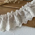 Cremeweiße Baumwollspitze mit floraler Stickerei für DIY-Projekte und Bekleidung - Schleifenmuster / Beige