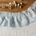 Hellblaue plissierte Baumwollspitze mit weißer Bogenstickerei und gewelltem Randdesign - Kreisknoten Muster / Hellblau