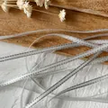 Silver metallic ribbon with woven edges for handmade DIY crafts and gift wrapping - White With Silver Trim 10 Meters Long And Approximately 0.3 Centimeters Wide.