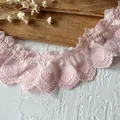 Gros plan de dentelle brodée de cœurs roses avec des bords plissés et festonnés - Rose
