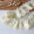 Détail macro de broderie cœur sur dentelle en coton crème avec bord festonné - Jaune Pâle