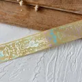 Detailed macro view of champagne gold ribbon with holographic laser snake and crown prints - Snake King (Silver Pattern) / Yellow