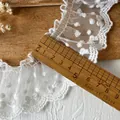 White polka dot embroidered lace trim with ruffled edges on rustic wood background - One Meter by Wide / White