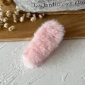 Pink plush oval hair accessory with soft faux fur texture on a wooden surface - Pink Bunny Ears