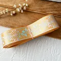 Floral ribbon roll with iridescent rose and star patterns in shiny golden yellow finish - Orange
