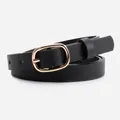 Classic black skinny belt for women with gold oval pin buckle on light gray backdrop - Black