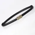 Women's black faux leather skinny belt featuring a stylish gold multi-ring tube buckle - Black