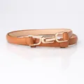 Slim brown leather belt with elegant golden double-loop buckle on white background - Camel