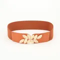 Women's brown elastic waist belt featuring a gold metal leaf buckle on white background - Camel